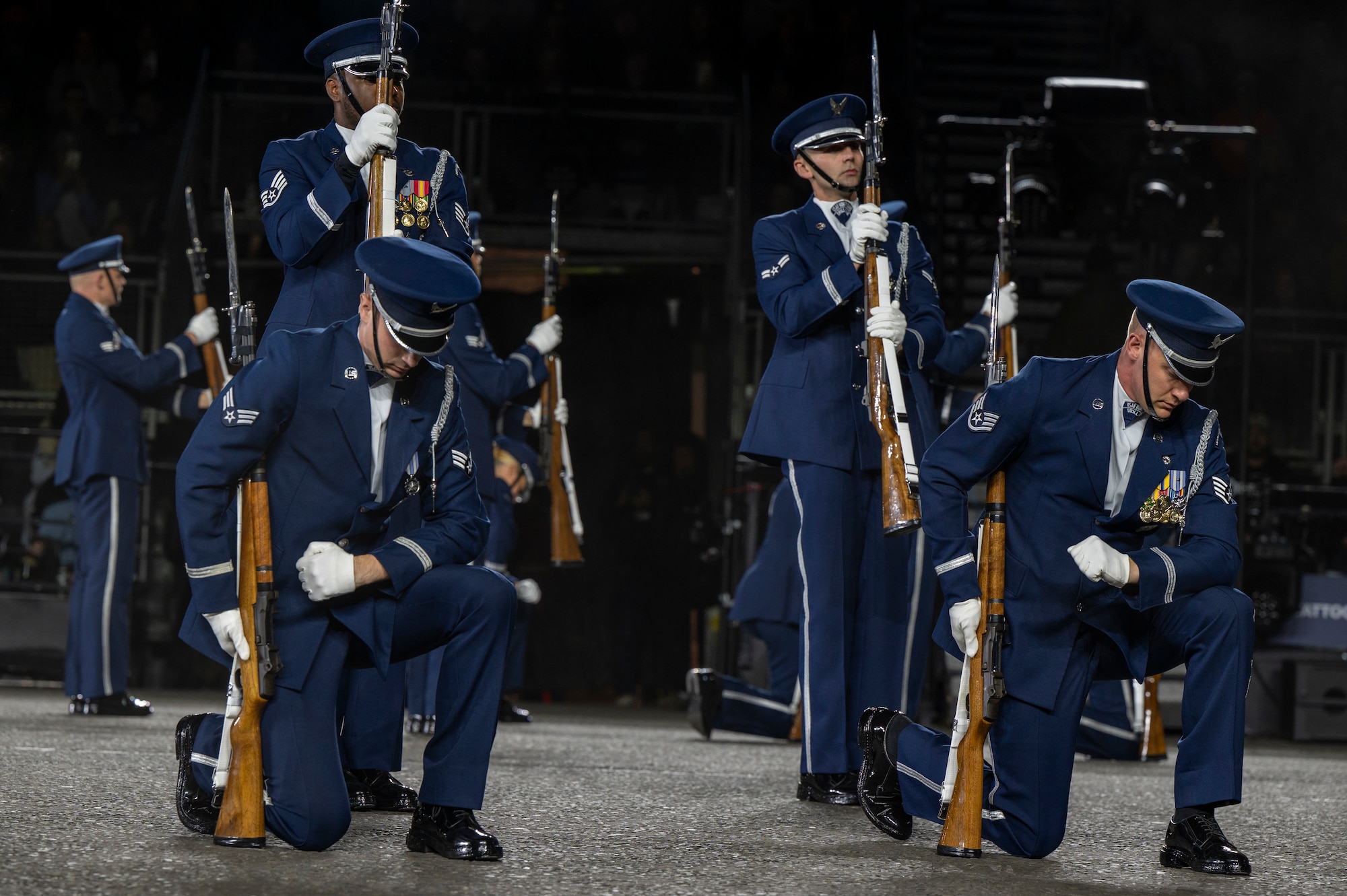 Members of the U.S. Air Force Honor Guard Drill Team kneel and stand during the kneeling bone crusher drill movement at the 75th Royal Edinburgh Military Tattoo in Edinburgh, Scotland, Aug. 1, 2025. Military bands and drill teams from the U.S., United Kingdom, Switzerland, Canada, Germany, Poland, and Ukraine performed during the 24-day event. (U.S. Air Force photo by Hayden Hallman)