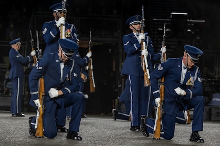 Members of the U.S. Air Force Honor Guard Drill Team kneel and stand during the kneeling bone crusher drill movement at the 75th Royal Edinburgh Military Tattoo in Edinburgh, Scotland, Aug. 1, 2025. Military bands and drill teams from the U.S., United Kingdom, Switzerland, Canada, Germany, Poland, and Ukraine performed during the 24-day event. (U.S. Air Force photo by Hayden Hallman)