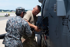U.S. Air Force Staff Sgt. John Marin, an HH-60W crew chief with the 106th Rescue Wing, works with a Japan Air Self-Defense Force refueling technician to refuel an HH-60W Jolly Green II search and rescue helicopter during exercise Resolute Force Pacific (REFORPAC) 2025 at Misawa Air Base, Japan, July 22, 2025.