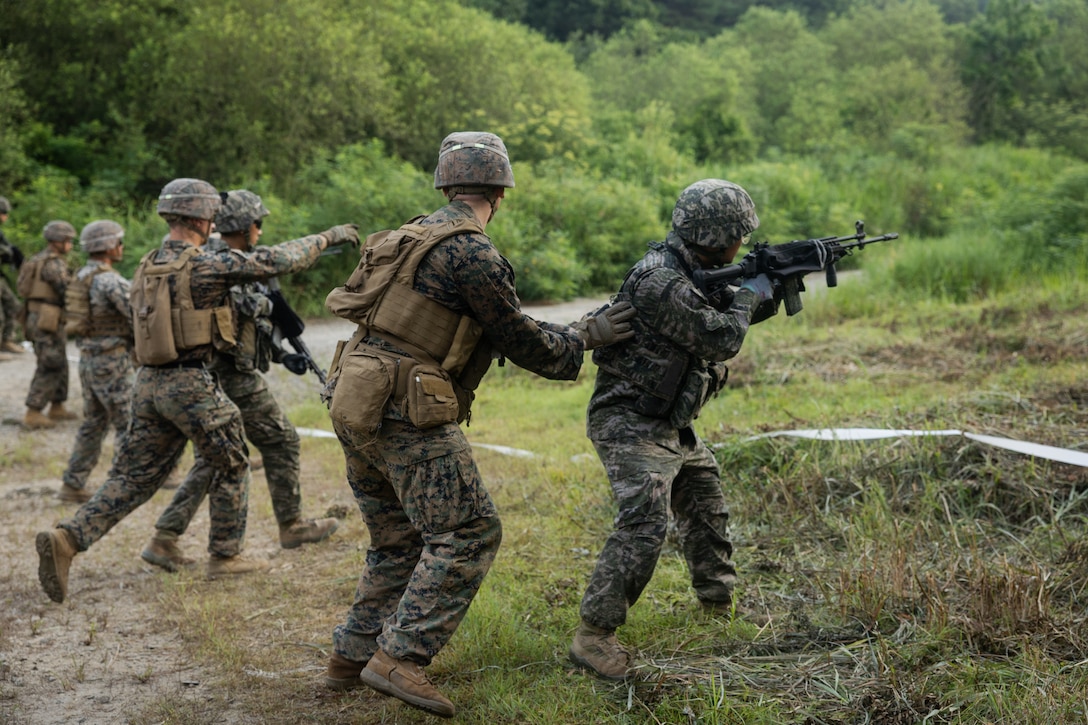 U.S. Marines with 2nd Battalion, 23rd Marines, forward deployed with 4th Marine Regiment, 3d Marine Division as part of the Unit Deployment Program, and Republic of Korea Marines conduct a reaction to contact drill during the Korean Marine Exercise Program 25.2 in Pocheon, South Korea, July 29, 2025. KMEP is conducted regularly between the ROK and U.S. Marine Corps to increase their combined capabilities through realistic training geared towards deterrence and maintaining peace in the Indo-Pacific. (U.S. Marine Corps photo by Lance Cpl. Van Hoang)