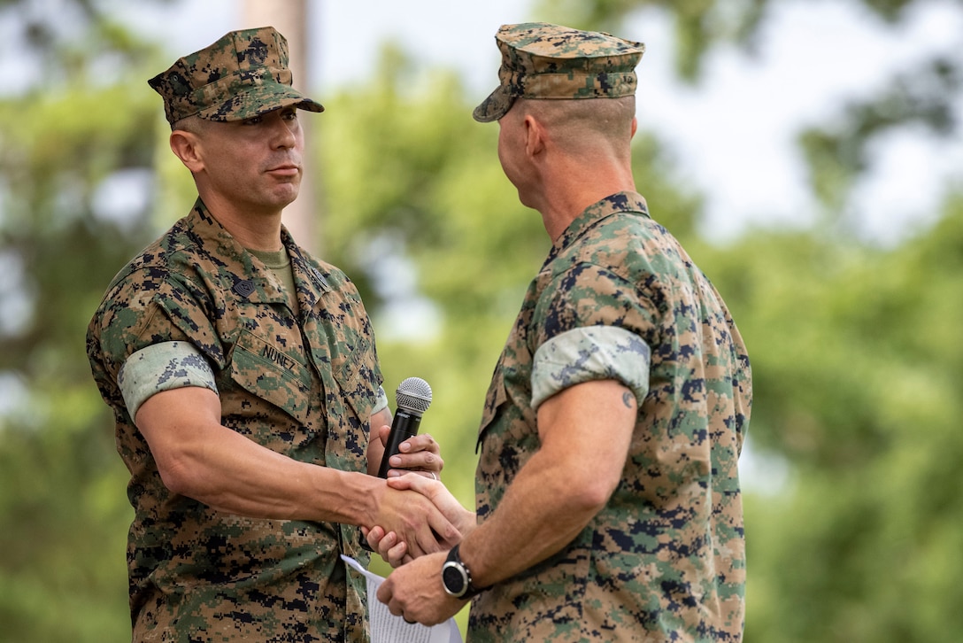 U.S. Marine Corps Sgt. Maj. Joseph A. Nunez, left, oncoming command senior enlisted advisor, exchanges a handshake with Sgt. Maj. Justin L. Burnette, off going command senior enlisted advisor, both with Headquarters and Headquarters Squadron, Marine Corps Air Station Cherry Point, during a relief and appointment ceremony at MCAS Cherry Point, North Carolina, Aug. 6, 2025.