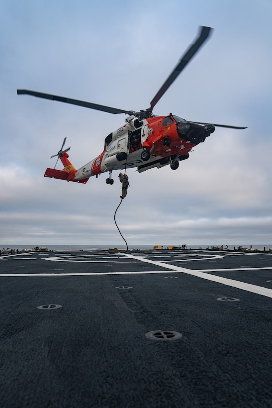 A member of U.S. Coast Guard Maritime Security Response Team West (MSRT-W) rappels from an MH-60 Jayhawk helicopter onto the flight deck of the U.S. Coast Guard Cutter Bertholf (WMSL 750) in the Pacific Ocean, June 26, 2025. MSRT units focus their efforts on law enforcement and maritime counterterrorism. (U.S. Coast Guard photo by Petty Officer 3rd Class Avery Tibbets)
