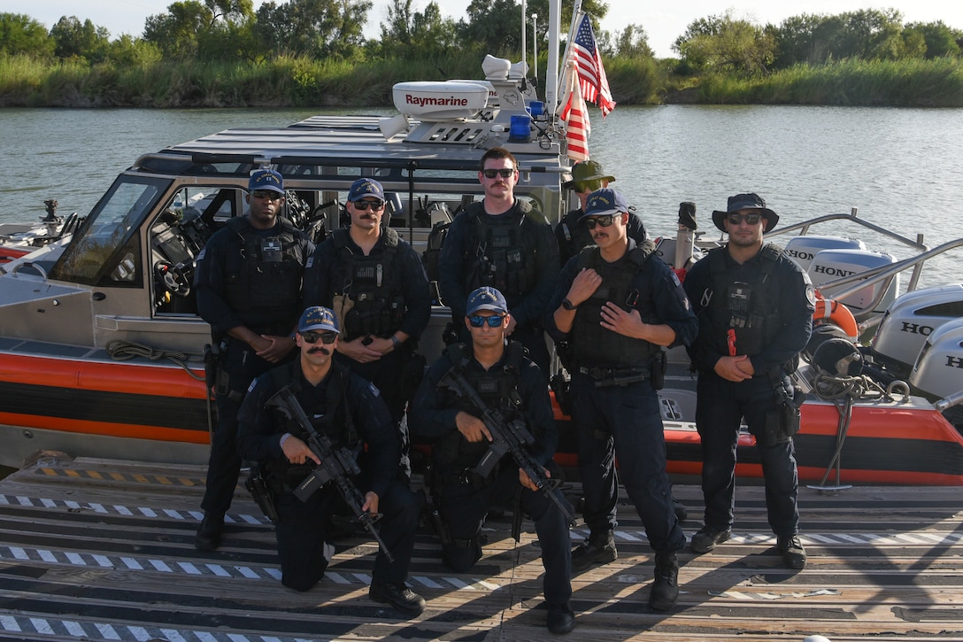 U.S. Coast Guard Maritime Safety and Security Team Houston (MSST), based in Houston, pose for a photograph in front of the Rio Grande in Mcallen, Texas, Aug. 7, 2025. The MSST team posed after a patrol on the river. (U.S. Coast Guard photo by PA3 Luke Baker)