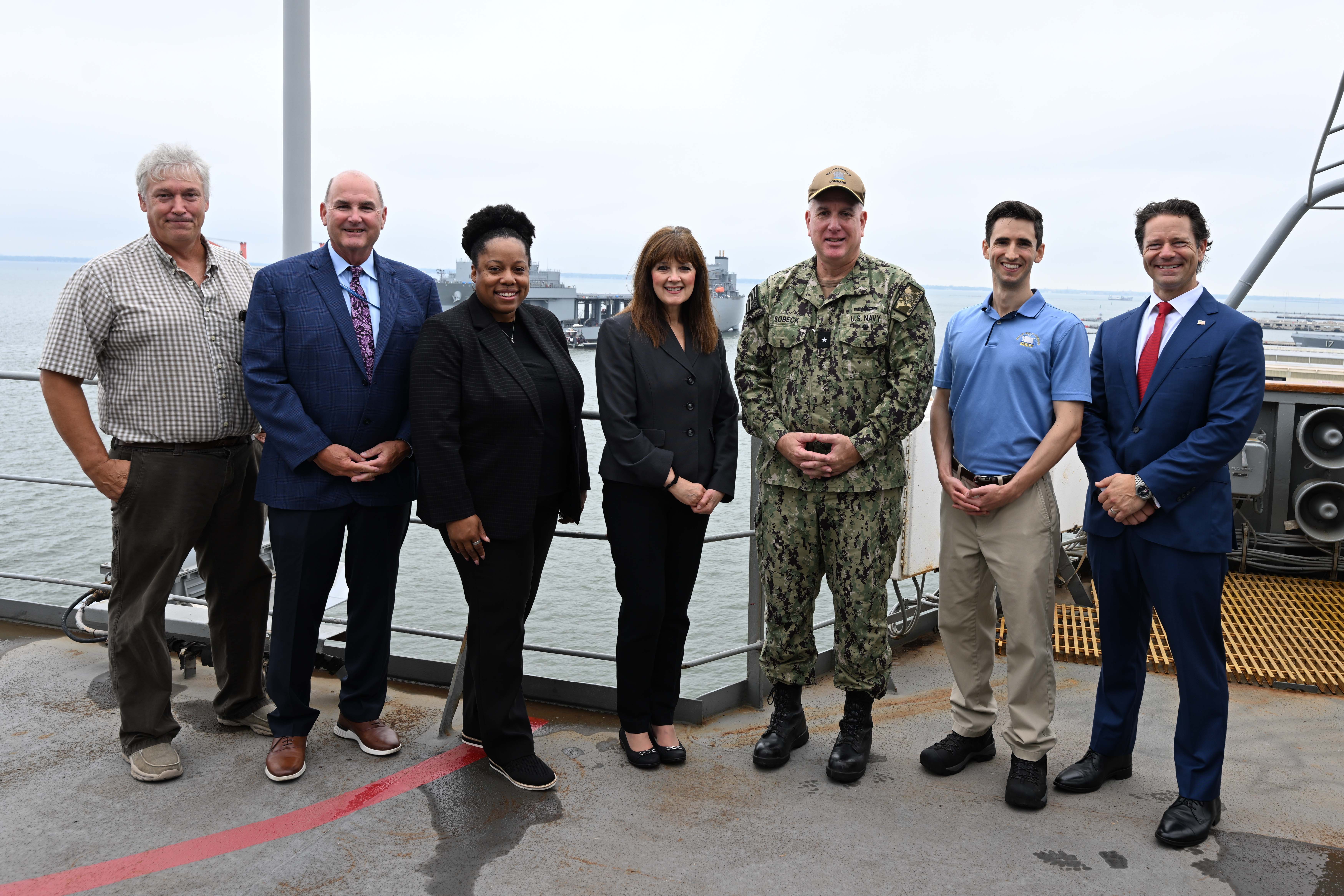 Assistant Secretary of the Navy (Manpower and Reserve Affairs) [far right], Mr. C Scott Duncan, Rear Adm. Philip E. Sobeck, Commander, Military Sealift Command [second from the right], and ship tour members, pose for a photo aboard USNS Patuxent (T-AO 201) during a ship tour, Aug.13, 2025.