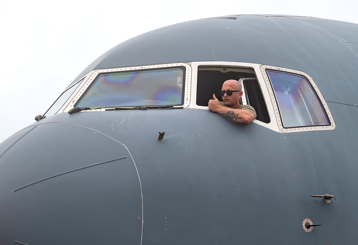 U.S. Air Force Senior Airman Steven Chambers, a crew chief assigned to the 22nd Aircraft Maintenance Squadron, signals he is ready to tow a KC-46 Pegasus aircraft to a new parking spot on the flight line during the U.S. Air Force’s 2025 Department-Level Exercise series at Andersen Air Force Base, Guam, July 24, 2025. The DLE strengthens and demonstrates the U.S. Air Force’s ability to reach theater at speed and scale, sustain operations, and rapidly pivot to any theater of operation at a moment’s notice while maintaining the strategic initiative. The DLE series encompasses all branches of the Department of Defense, along with Allies and partners, employing more than 400 joint and coalition aircraft and more than 12,000 personnel across more than 50 locations across 3,000 miles. (U.S. Air Force photo by Staff Sgt. Tryphena Mayhugh)