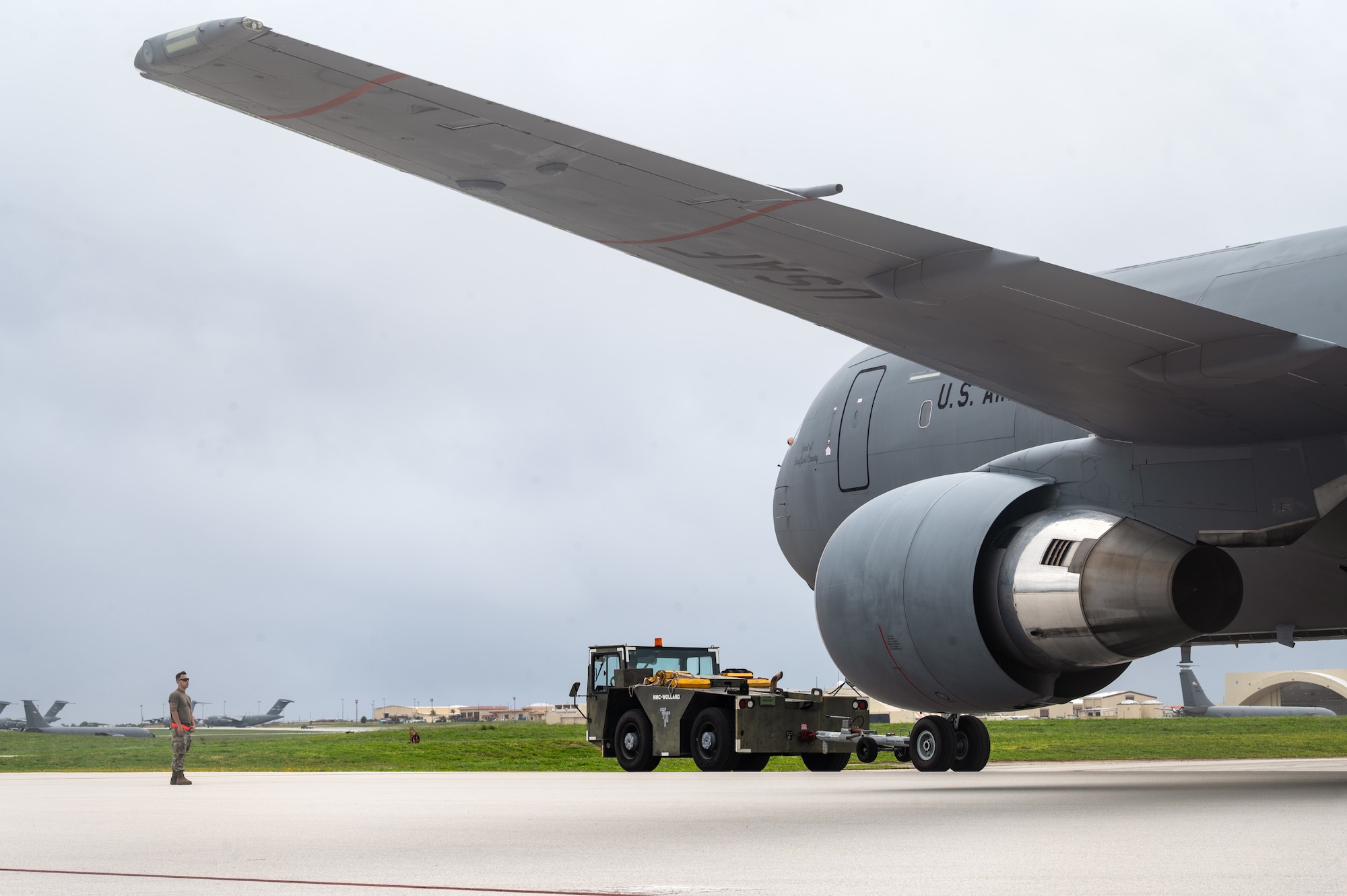 Airmen assigned to the 22nd Aircraft Maintenance Squadron and the 64th Air Refueling Squadron tow a KC-46 Pegasus aircraft to a new parking spot on the flight line during the U.S. Air Force’s 2025 Department-Level Exercise series at Andersen Air Force Base, Guam, July 24, 2025. The DLE strengthens and demonstrates the U.S. Air Force’s ability to reach theater at speed and scale, sustain operations, and rapidly pivot to any theater of operation at a moment’s notice while maintaining the strategic initiative. The DLE series encompasses all branches of the Department of Defense, along with allies and partners, employing more than 400 joint and coalition aircraft and more than 12,000 personnel across more than 50 locations across 3,000 miles. (U.S. Air Force photo by Staff Sgt. Tryphena Mayhugh)