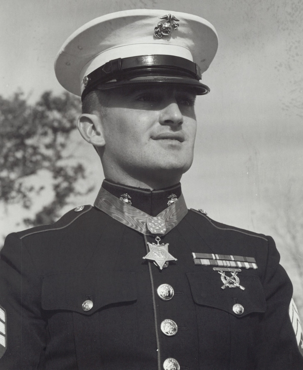 A person in a military dress uniform looks into the distance.