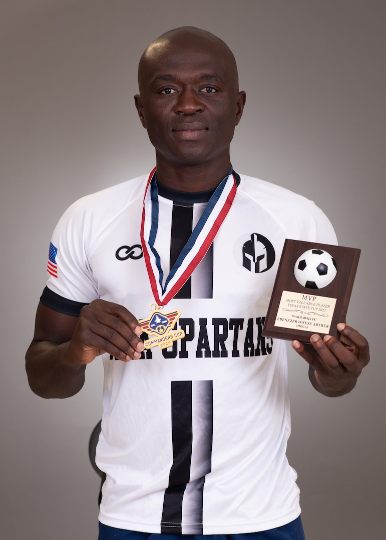 Senior Airman Ebenezer Owusu Arthur, 59th Medical Wing, displays a Commanders Cup medal and Most Valuable Player award following his performance in a military soccer tournament in Utah.