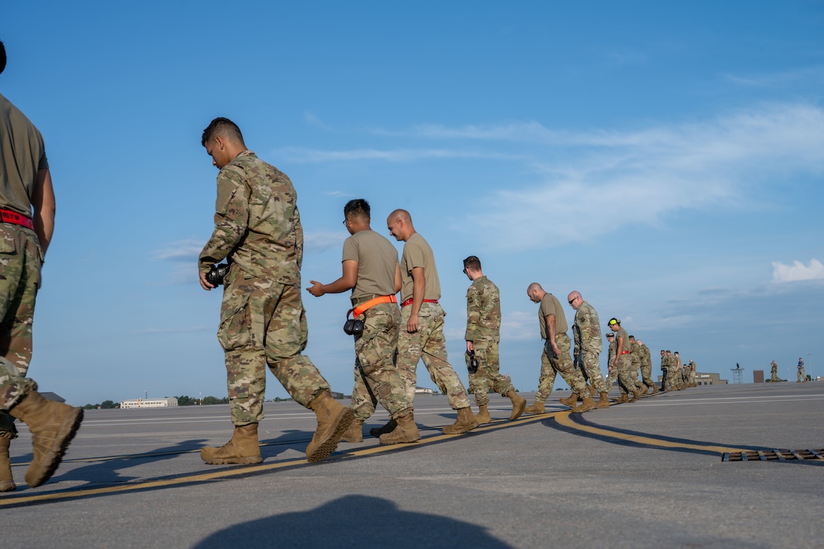 Airmen from the 722nd Aircraft Maintenance Squadron and the 22nd Maintenance Squadron participate in a weekly foreign object debris (FOD) walk at McConnell Air Force Base, Kansas, Aug. 12, 2025. The maintenance teams collected over 1 pound of FOD. (U.S. Air Force photo by Airman 1st Class Paula Arce)