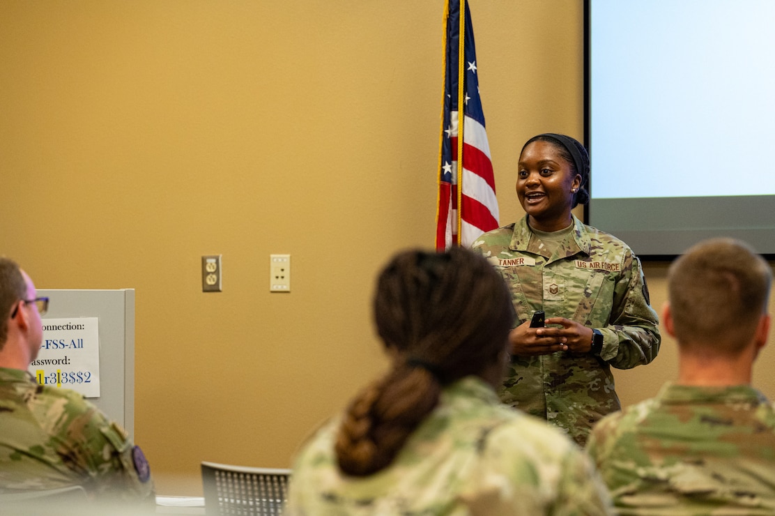 U.S. Air Force Master Sgt. Jasmine Tanner, Military and Family Readiness Center readiness noncommissioned officer in charge, gives a post deployment brief to Barksdale Airmen at Barksdale Air Force Base, Louisiana, Aug. 6, 2025. Post deployment briefs bring together resources from different agencies to help Airmen reintegrate from deployment. (U.S. Air Force photo by Airman 1st Class Aaron Hill)