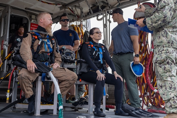 Rear Adm. Dianna Wolfson, Fleet Maintenance Officer, U.S. Fleet Forces Command (USFFC), dons diving gear prior to an underwater maintenance inspection of the San Antonio-class amphibious transport dock ship USS San Antonio (LPD 17) with active-duty and civilian Navy divers from Mid-Atlantic Regional Maintenance Center, August 8, 2025. USFFC is responsible for manning, training, equipping and providing combat-ready forces forward to numbered fleets and combatant commanders around the globe. (U.S. Navy photo by Chief Mass Communication Specialist Evan Thompson/Released)
