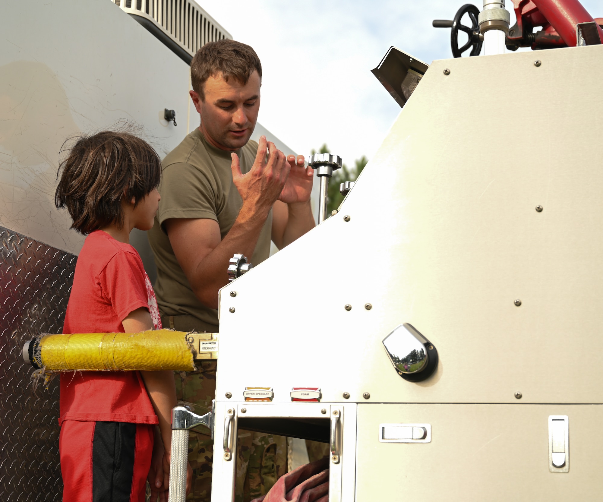 Tech. Sgt. Swartz explains the controls of the water cannon to a child.