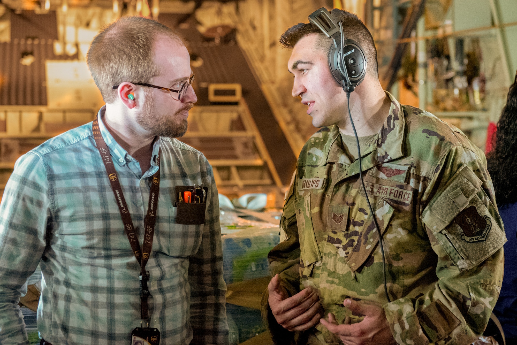 Staff Sgt. Tyler Phillips, a loadmaster from the Kentucky Air National Guard's 165th Airlift Squadron, explains his duties to a civilian employer during an orientation flight over Kentucky aboard a C-130J Super Hercules as part of a "Bosslift" held May 14, 2025. The federal program, sponsored by Employer Support of the Guard and Reserve, is designed to give civilian employers a deeper understanding of Guard missions. (U.S. Air National Guard photo by Senior Airman Annaliese Billings)