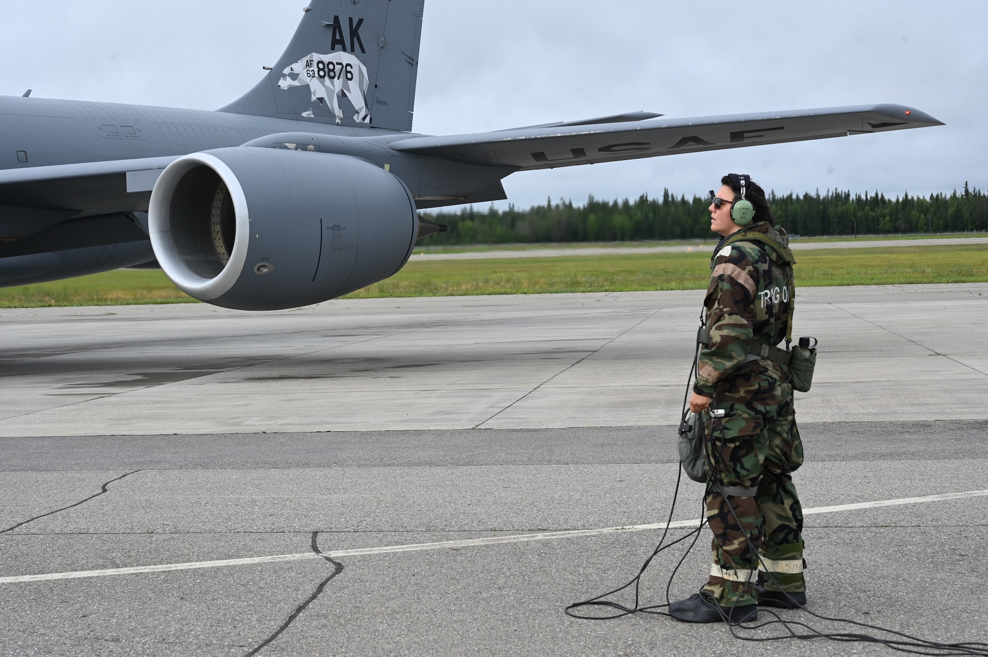 U.S. Air National Guard Tech Sgt. Kayla Bishop, 168th Wing crew chief, prepares to launch a KC-135 Stratotanker as she talks to the pilots and the engines start up.