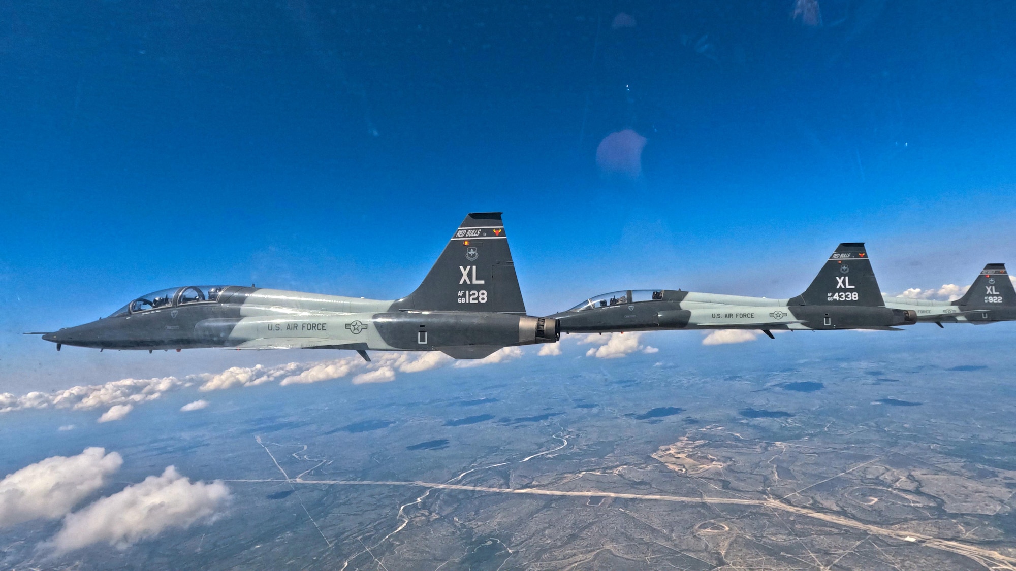 A three-ship formation of T-38C Talon aircraft flies over Laughlin Air Force Base, Texas, during a non-standard airspace training exercise, Aug. 7, 2025. The exercise emphasized fighter and bomber fundamentals, allowing instructor pilots to hone advanced formation flying and tactical maneuvering. (U.S. Air Force photo by Airman 1st Class Harrison Sullivan)