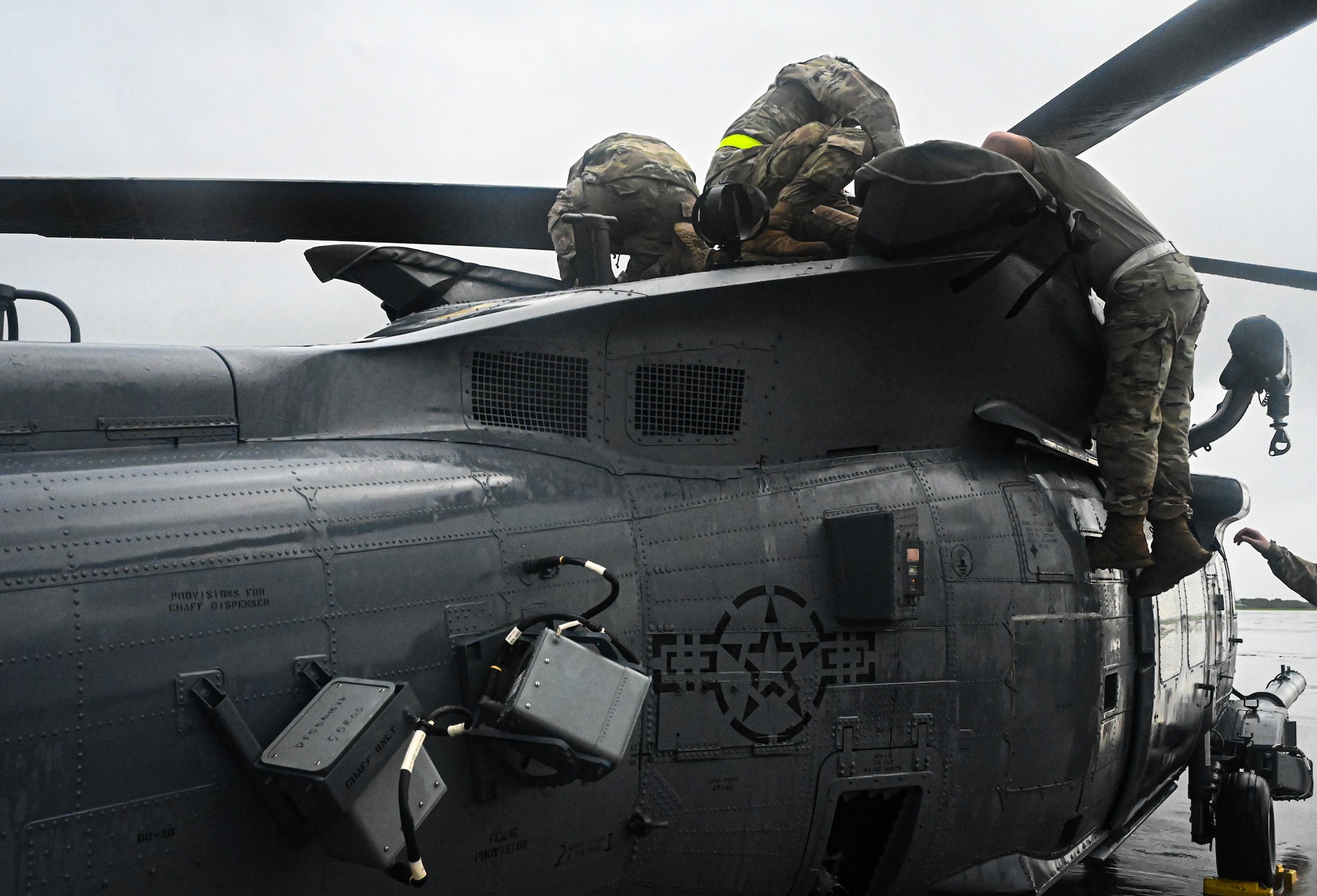 U.S. Air Force Airmen from the 563rd Rescue Group perform maintenance on a HH-60W Jolly Green II helicopter in the rain during exercise Resolute Force Pacific in Saipan, Northern Mariana Islands, July 23, 2025. REFORPAC is the Air Force’s largest contingency response exercise ever conducted in the Pacific. (U.S. Air Force photo by 2nd Lt. Grace Brandt)