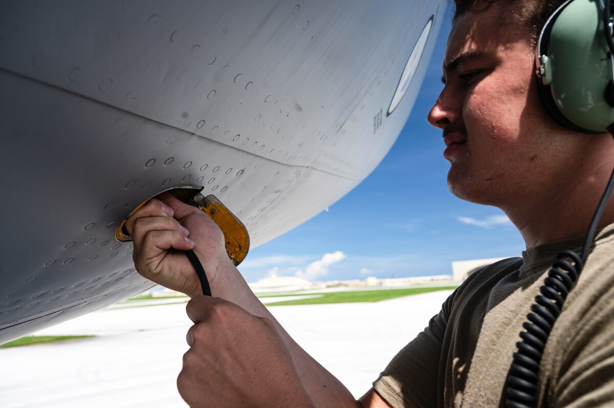 Airman 1st Class Cameron Zorns, 6th Aircraft Maintenance Squadron crew chief, plugs his headset into a KC-135 Stratotanker assigned to McConnell Air Force Base, Kansas, during the U.S. Air Force Department-Level Exercise series at Andersen Air Force Base, Guam, July 15, 2025. The DLE strengthens and demonstrates the U.S. Air Force’s ability to reach theater at speed and scale, sustain operations, and rapidly pivot to any theater of operation at a moment’s notice while maintaining the strategic initiative. The DLE series encompasses all branches of the Department of Defense, along with allies and partners, employing more than 400 joint and coalition aircraft and more than 12,000 personnel across more than 50 locations across 3,000 miles. (U.S. Air Force photo by Staff Sgt. Tryphena Mayhugh)
