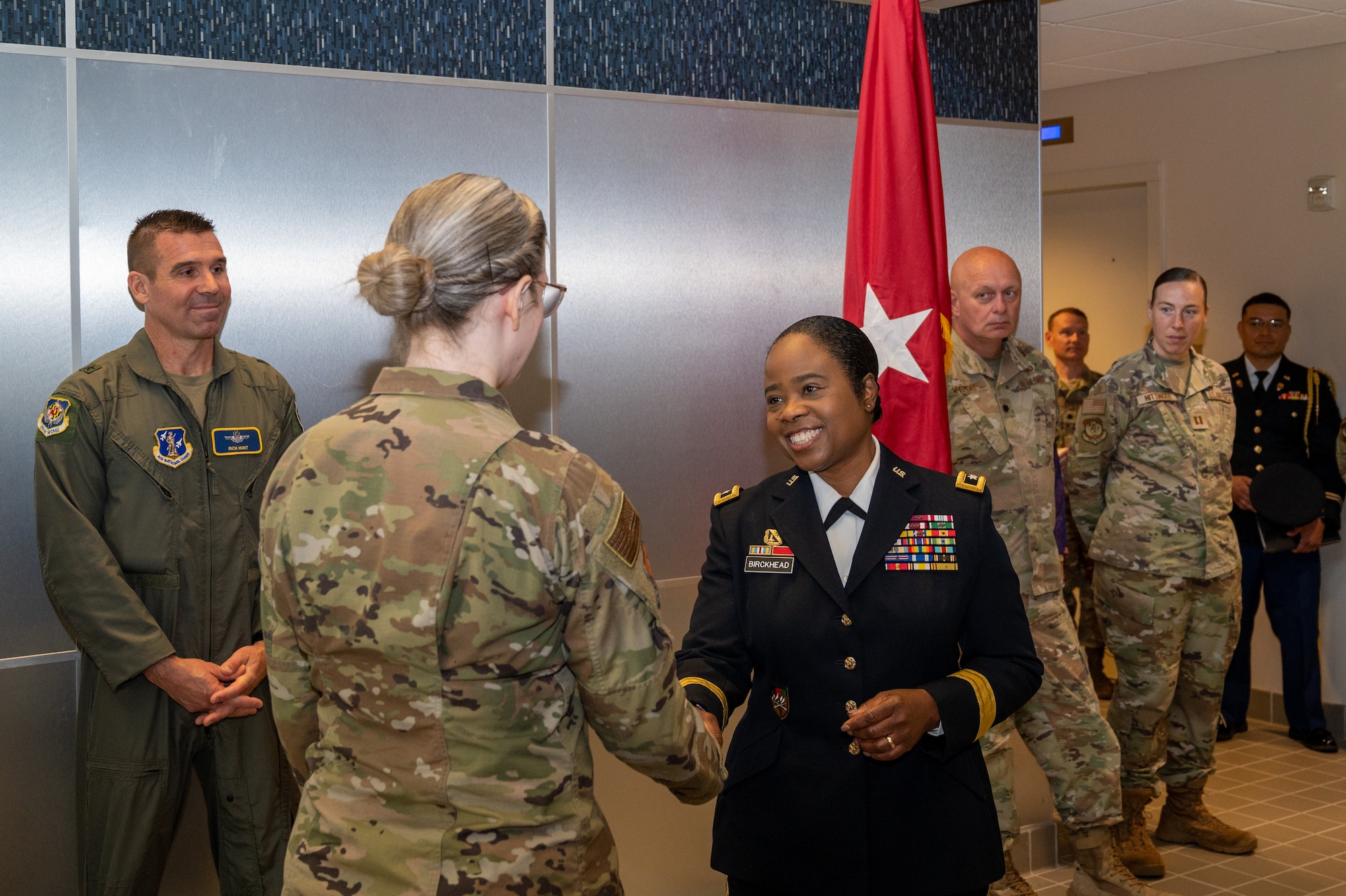 Maryland Army National Guard Maj. Gen. Janeen L. Birckhead, adjutant general for the Maryland National Guard, shakes hands with Maryland Air National Guard Staff Sgt. Rachel Underwood, public affairs specialist for the 175th Wing, during a mural recognition ceremony in the headquarters building at Warfield Air National Guard Base at Martin State Airport, Maryland, August 10, 2025. Underwood was recognized during the ceremony for painting the three-panel acrylic mural, two panels spanning 14.5 feet by 8 feet, and a center panel of 16.5 feet by 6 feet, over the course of a year in order to tell the story of the Maryland Air National Guard and to be hung at the entrance of the 175th Wing headquarters’ building. (U.S. Air National Guard Photo by Staff Sgt. Julian Kemper)