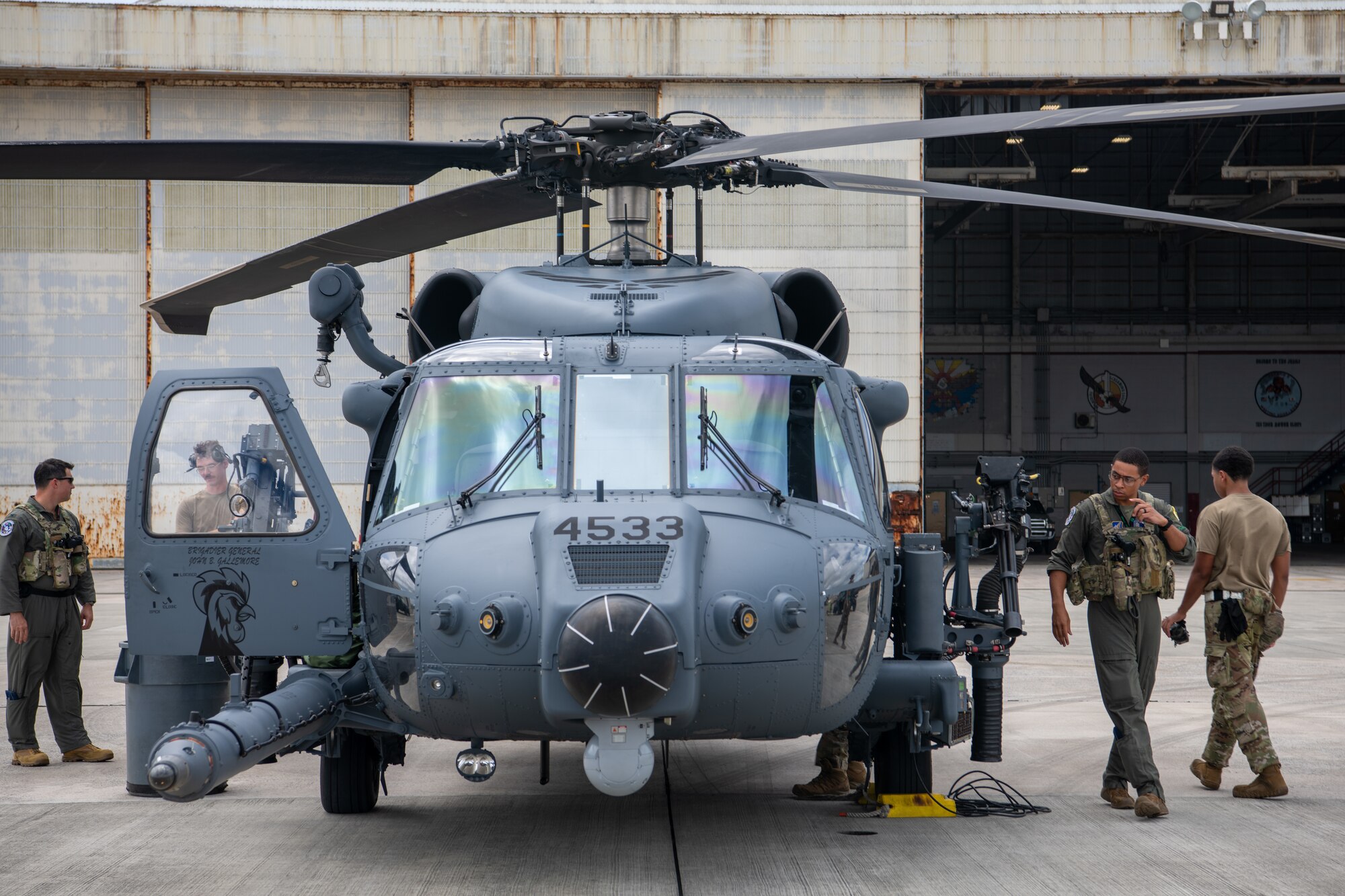 front view of a helicopter while military members walk around it