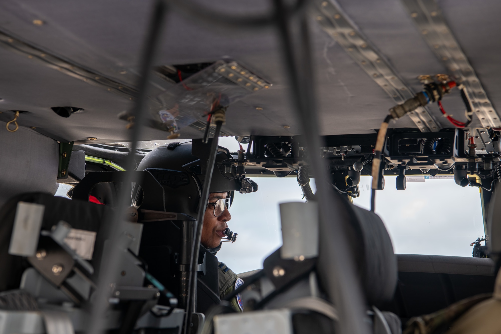 inside view of a pilot sitsting in the pilots seat of a helicopter and looks to the side