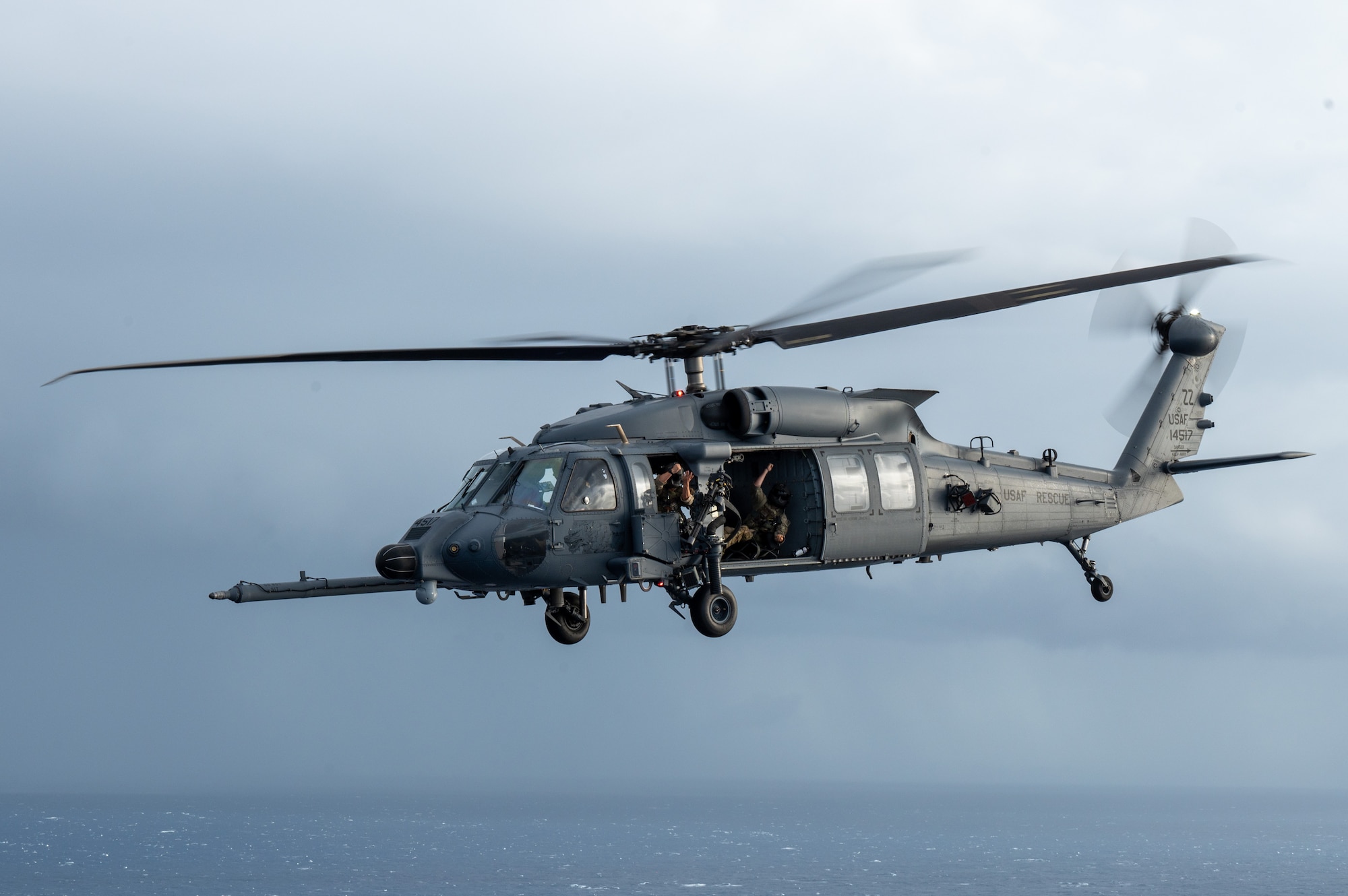 a helicopter flies with military members posing