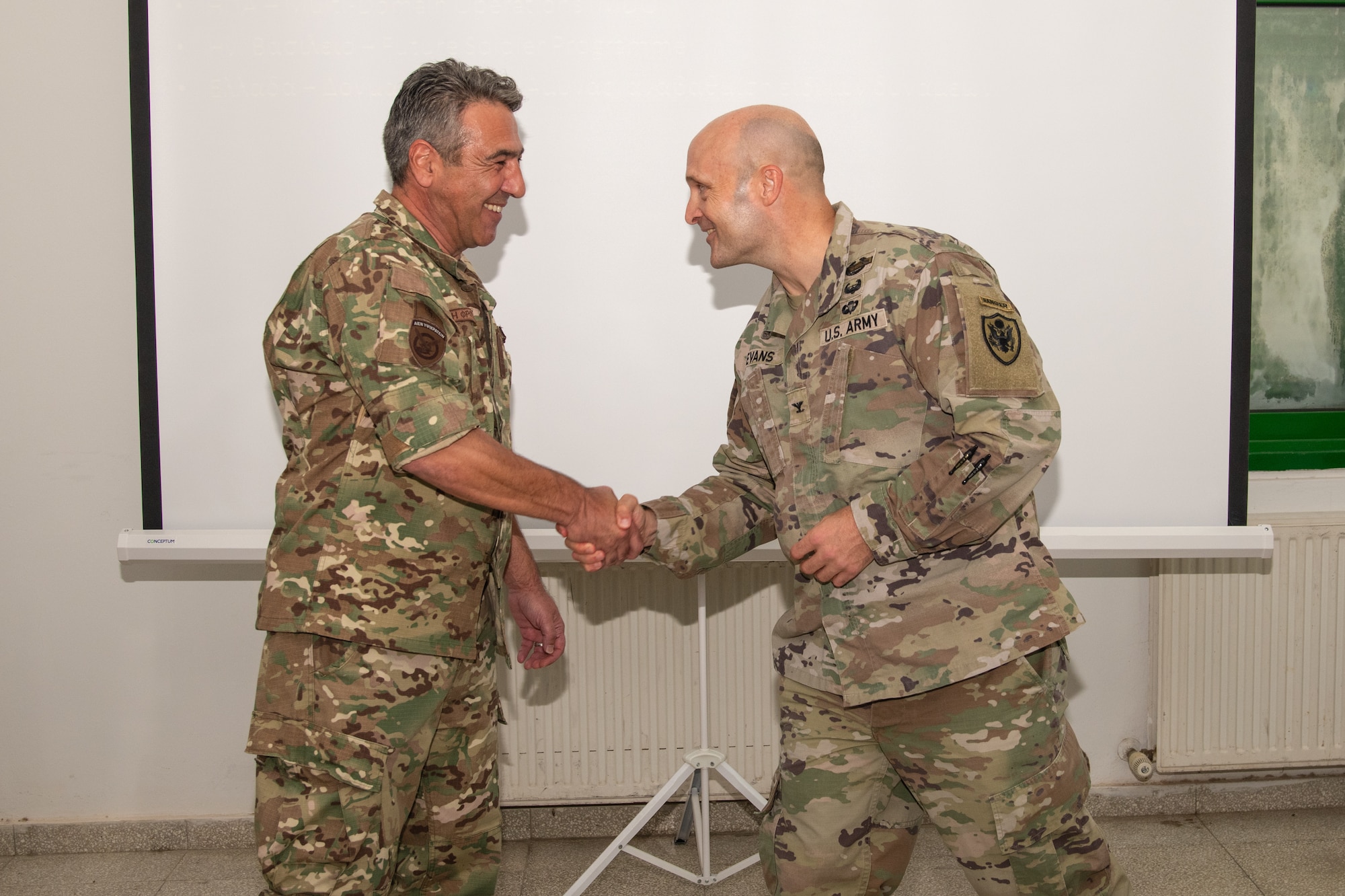 Cypriot Warrant Officer Andreas Christoforou shakes hands with U.S. Army Col. K.C. Evans.