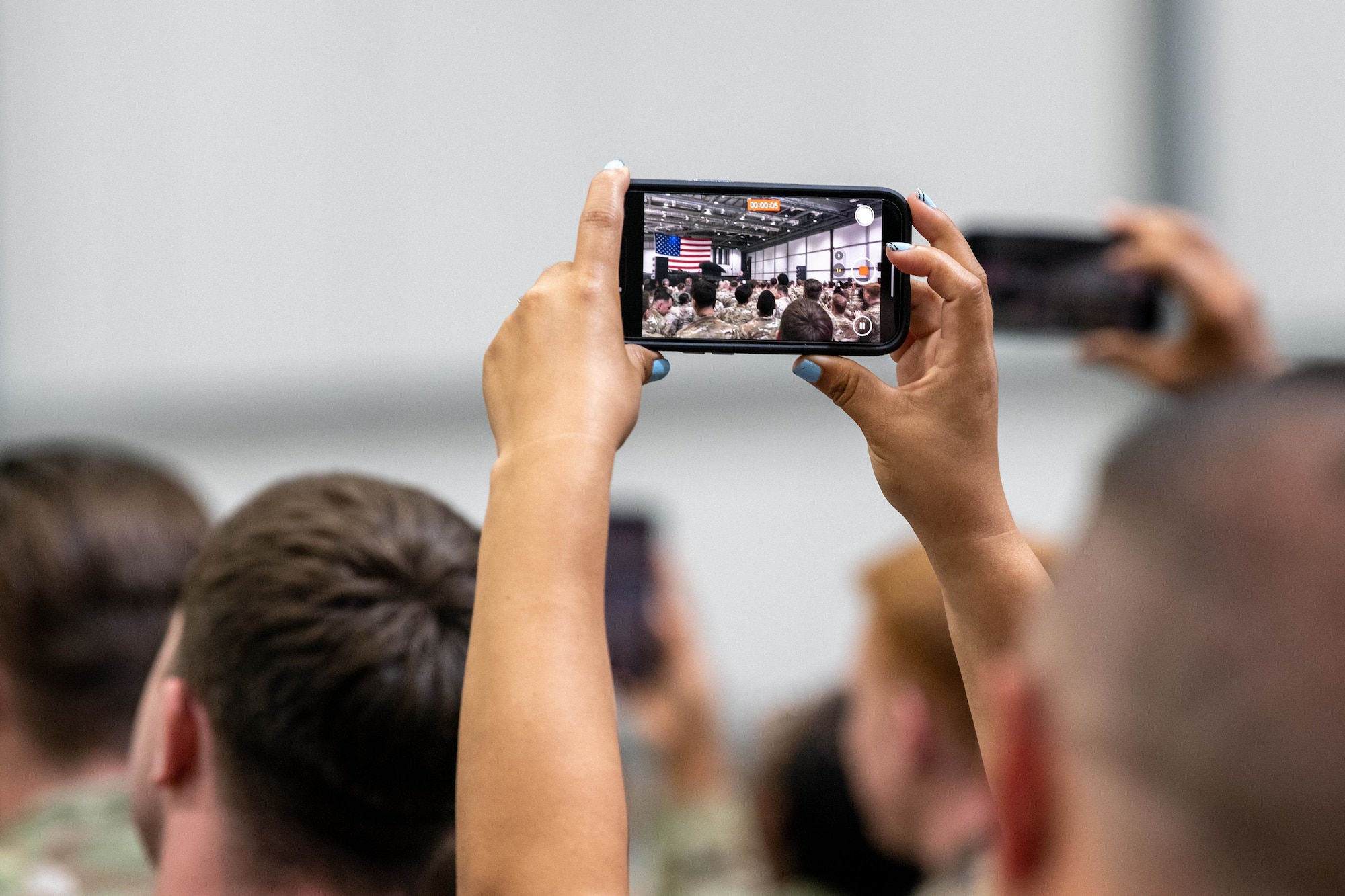 An attendee films the arrival of U.S. Vice President JD Vance
