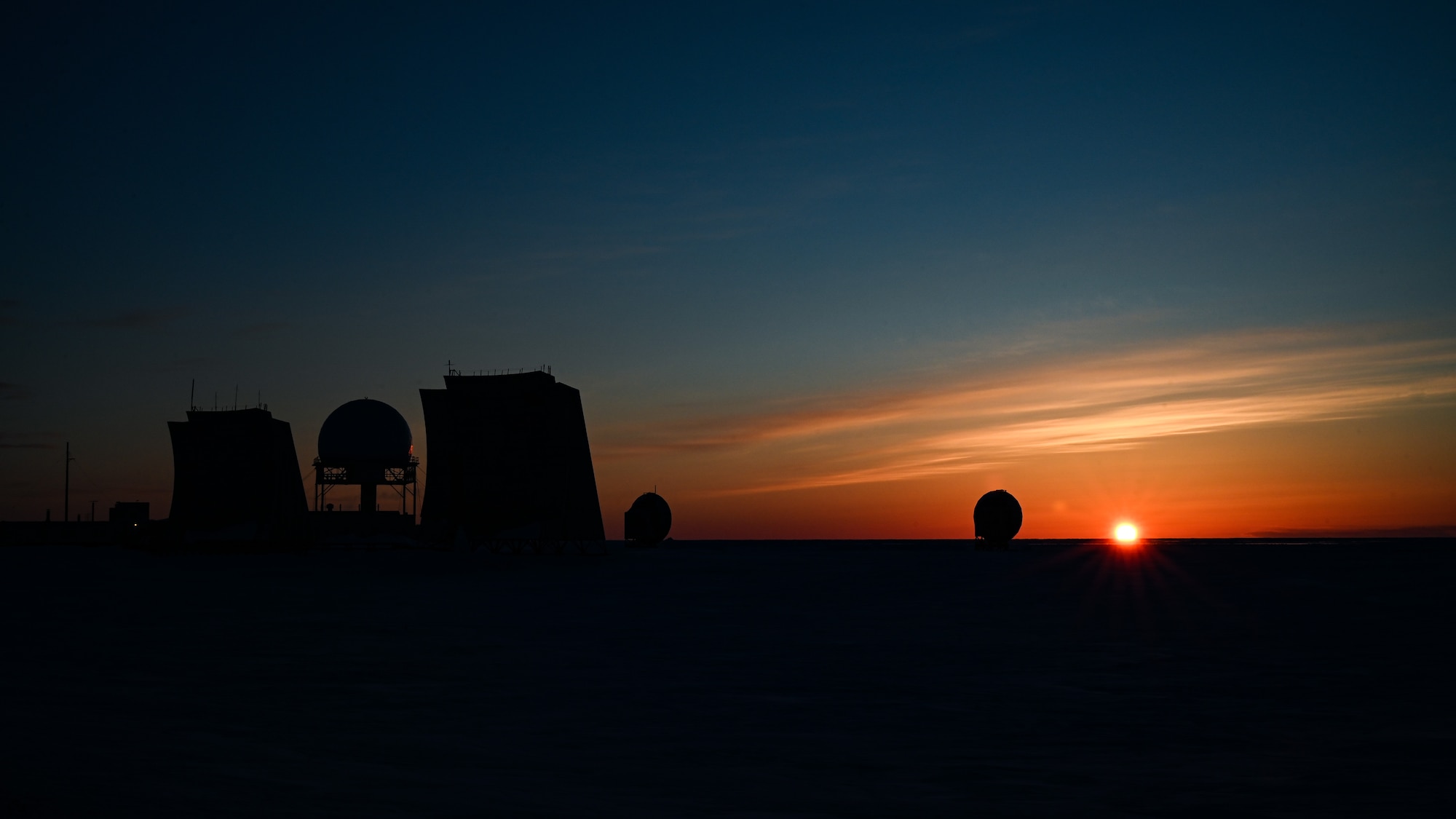 The morning sun rises over the North Warning System Site .