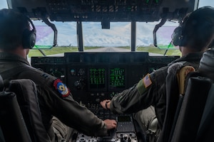 airmen provide patient care in the back of a C-130J Super Hercules