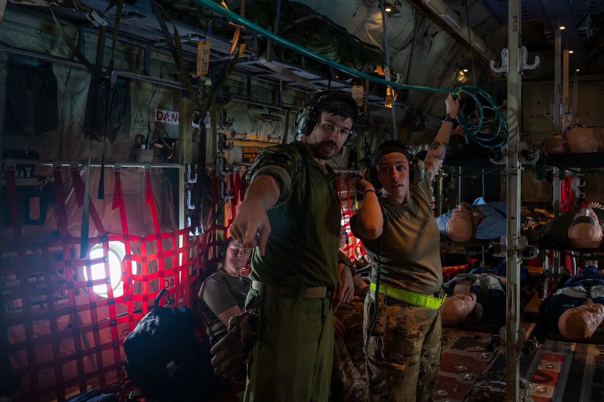 airmen provide patient care in the back of a C-130J Super Hercules