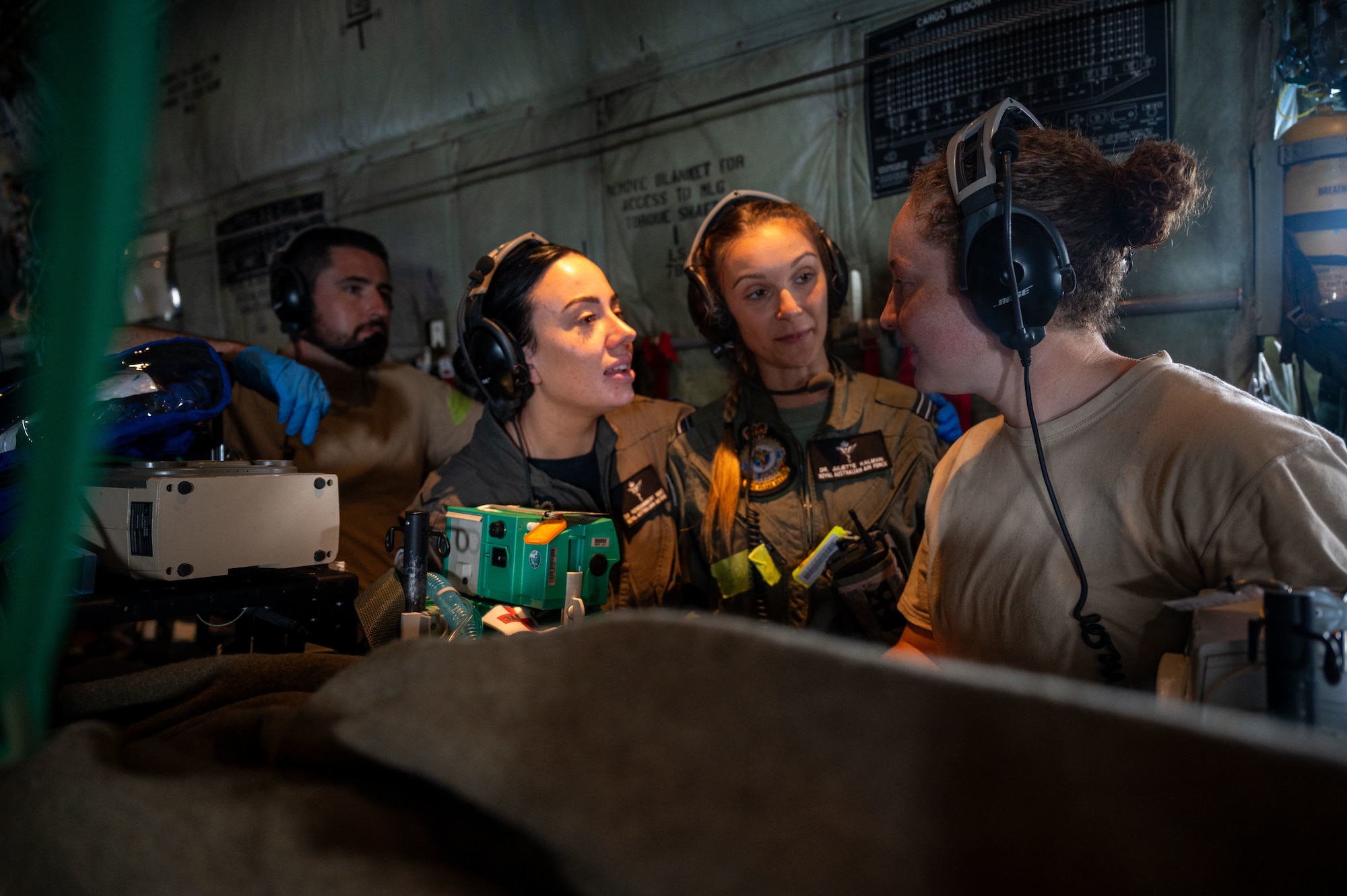 airmen provide patient care in the back of a C-130J Super Hercules