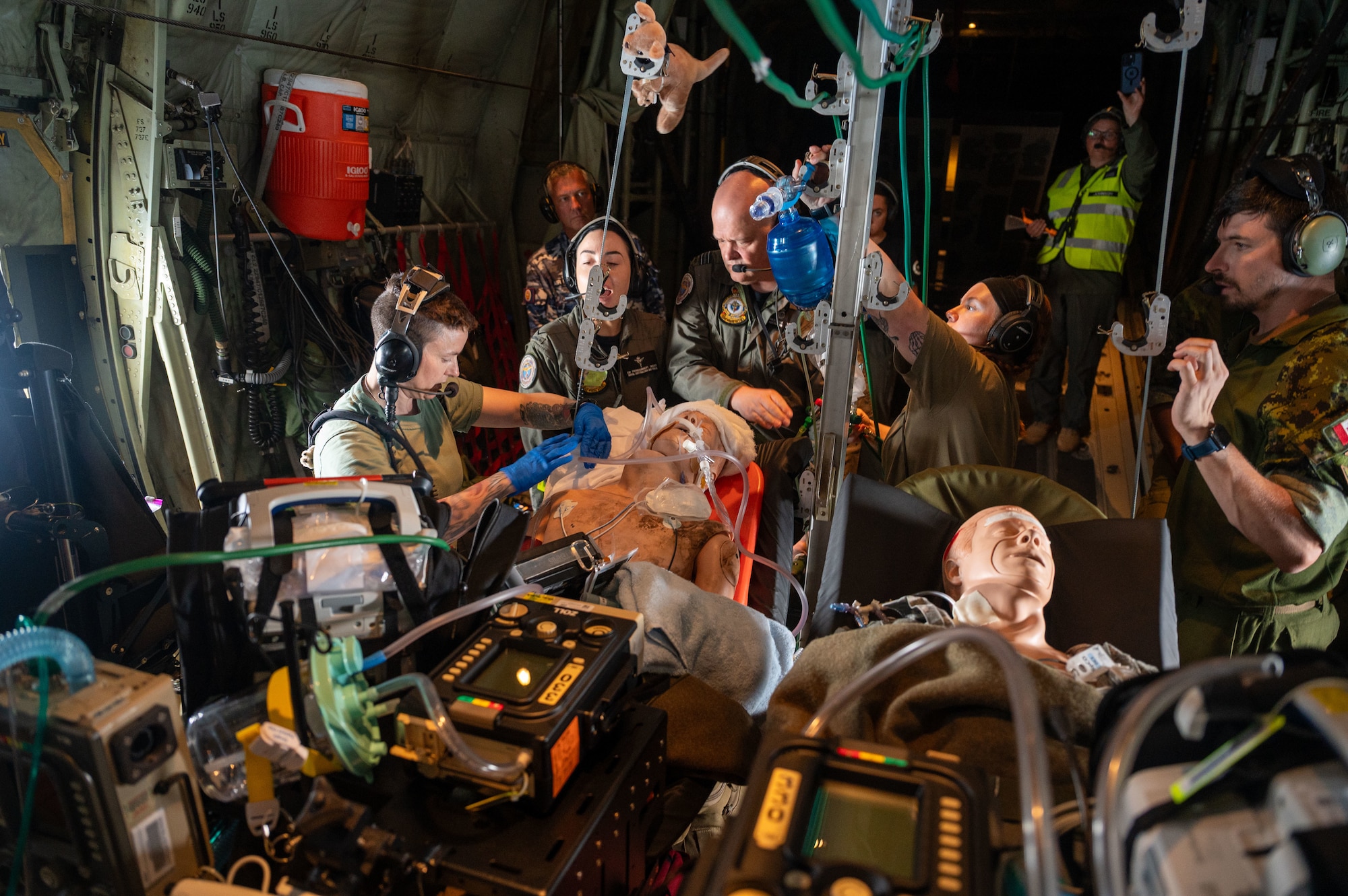 airmen provide patient care in the back of a C-130J Super Hercules