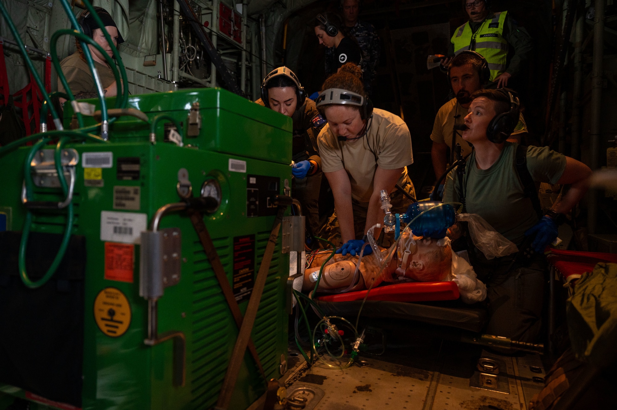 airmen provide patient care in the back of a C-130J Super Hercules