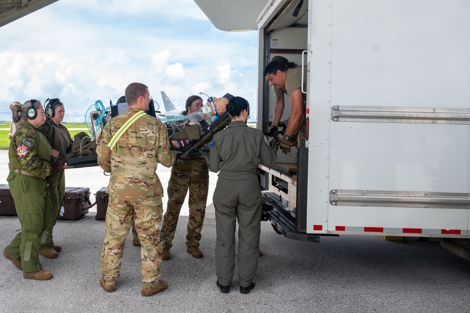 airmen load a stretcher onto a van