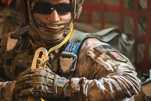 A Chilean Paracaidista waits for the command to hook up his static line to the cable in a C-130H Hercules.