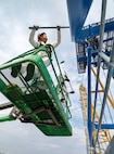 Darius Aldan, work lead, and Romeo Aquino, painter, Code 730, Crane Maintenance, are part of six-person team repainting Portal Cranes 80, 82 and 92 at Puget Sound Naval Shipyard & Intermediate Maintenance Facility in Bremerton, Washington. The paints used are silicone alkyd enamel, with a higher gloss sheen added for ease of cleaning purposes, and for better UV deflection. (U.S. Navy photo by Wendy Hallmark)