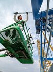 Darius Aldan, work lead, and Romeo Aquino, painter, Code 730, Crane Maintenance, are part of six-person team repainting Portal Cranes 80, 82 and 92 at Puget Sound Naval Shipyard & Intermediate Maintenance Facility in Bremerton, Washington. The paints used are silicone alkyd enamel, with a higher gloss sheen added for ease of cleaning purposes, and for better UV deflection. (U.S. Navy photo by Wendy Hallmark)