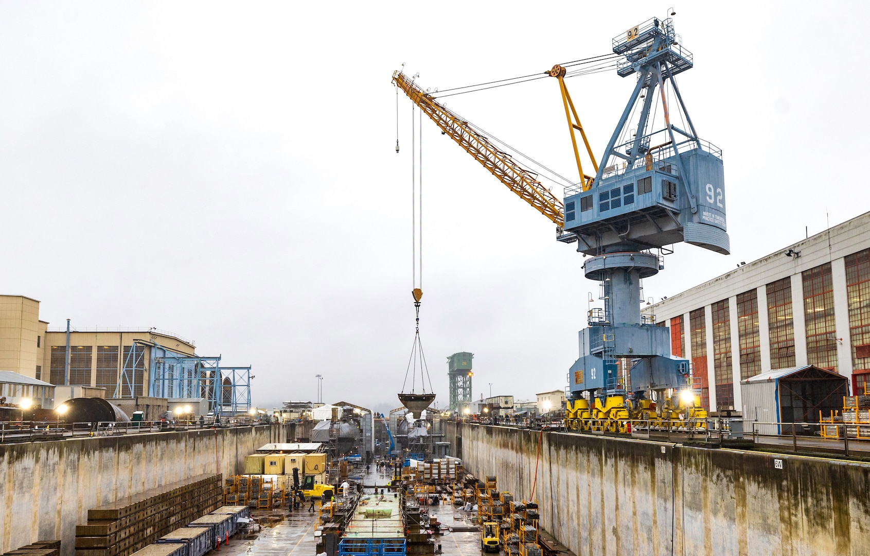 Crane 92 (pictured in 2024, before repainting) will soon sport a darker blue look at Puget Sound Naval Shipyard & Intermediate Maintenance Facility in Bremerton, Washington. A six-person team of painters is working hard throughout the short Pacific Northwest summer to repaint cranes 80, 82 and 92. The paints used are silicone alkyd enamel, with a higher gloss sheen added for ease of cleaning purposes, and for better UV deflection. (U.S. Navy photo by Wendy Hallmark)