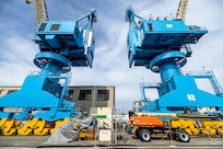 Portal cranes 80 and 82 are pictured after receiving a fresh coat of paint in July of 2025, at Puget Sound Naval Shipyard & Intermediate Maintenance Facility in Bremerton, Washington. A six-person team of painters is working hard throughout the short Pacific Northwest summer to repaint cranes 80, 82 and 92. (U.S. Navy photo by Jeb Fach)