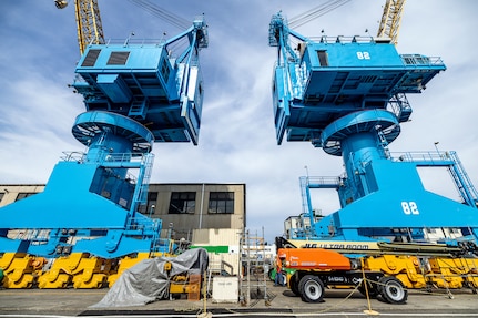 Portal cranes 80 and 82 are pictured after receiving a fresh coat of paint in July of 2025, at Puget Sound Naval Shipyard & Intermediate Maintenance Facility in Bremerton, Washington. A six-person team of painters is working hard throughout the short Pacific Northwest summer to repaint cranes 80, 82 and 92. (U.S. Navy photo by Jeb Fach)