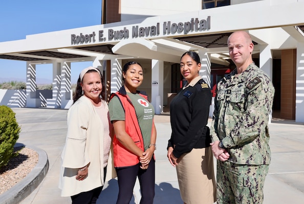Customer Service Officer Gina Buffaloe (left), American Red Cross Volunteer Kiera Martin (left-center), Cmdr. Christine Higgins (right-center), and American Red Cross liaison Chaplain Lt. Cmdr. Nicholas Suddath (right) pictured at Robert E. Bush Naval Hospital, August 5, 2025. The group is part of a renewed effort between the hospital’s Patient and Family Partnership Council and the American Red Cross to reestablish a strong volunteer presence, with Martin— a nursing student and military spouse—already making a notable impact at command events. (Official U.S. Navy Photo by Christopher Jones, NHTP/NMRTC Twentynine Palms public affairs officer).