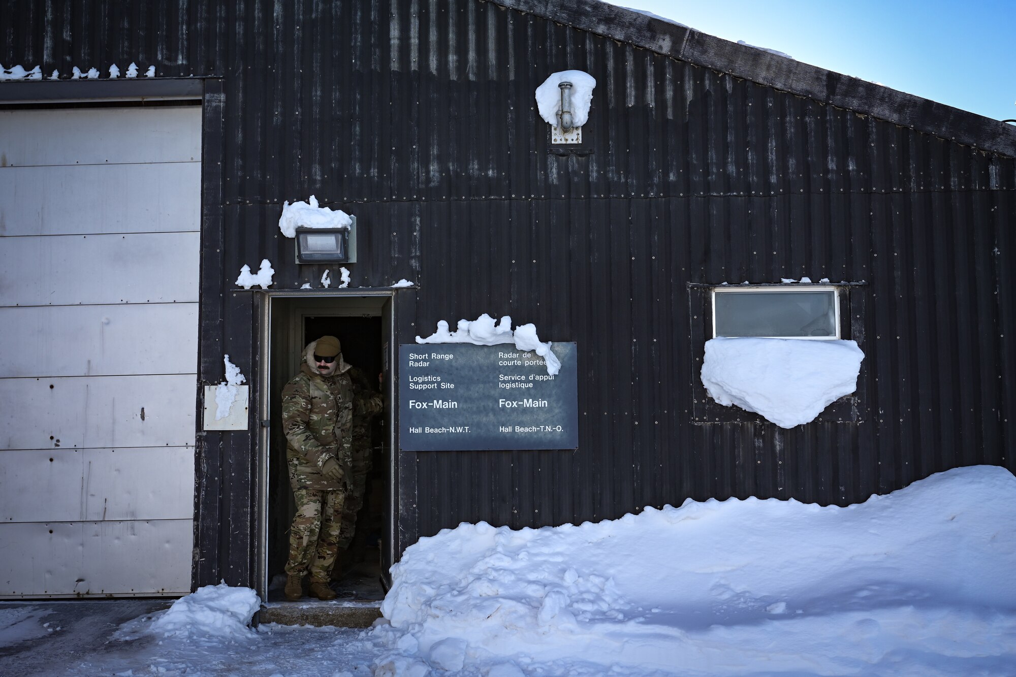 U.S. Air Force Lt. Col. Alexander White, Acquisition Management and Integration Center Detachment 1 commander, exits a logistics facility at North Warning System Site FOX-M Hall Beach.