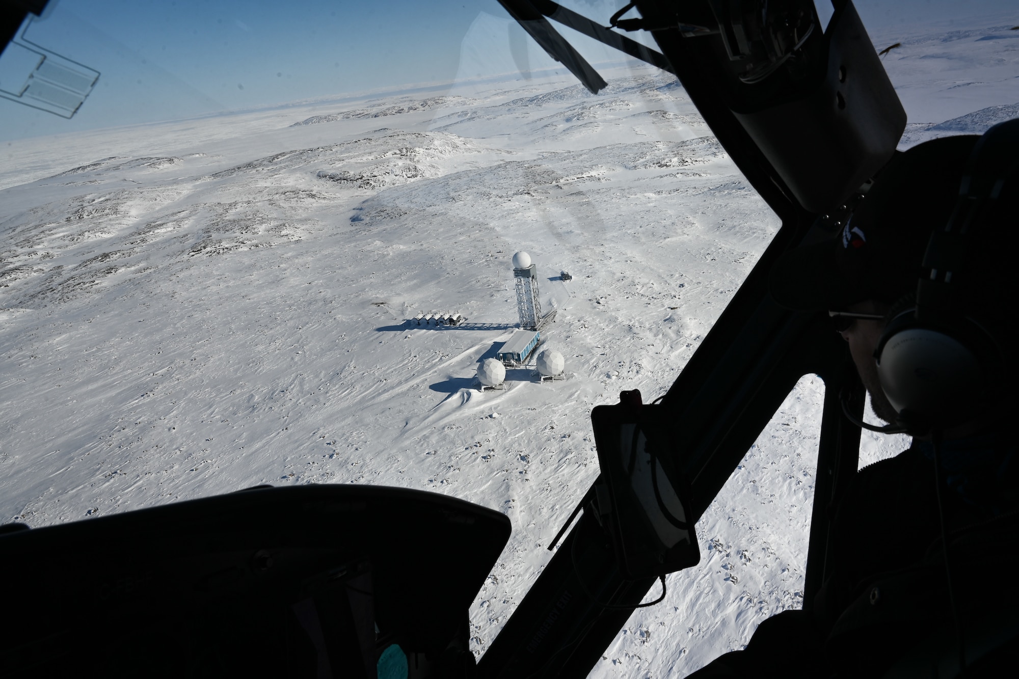 A helicopter flies over North Warning System Site CAM-5A
