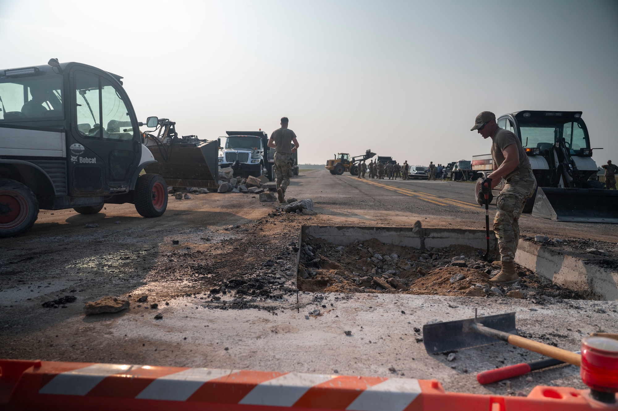 United States Air Force service members perform repairs to an airfield taxiway