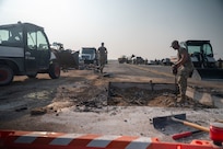 United States Air Force service members perform repairs to an airfield taxiway