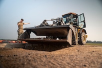 United States Air Force service members perform repairs to an airfield taxiway