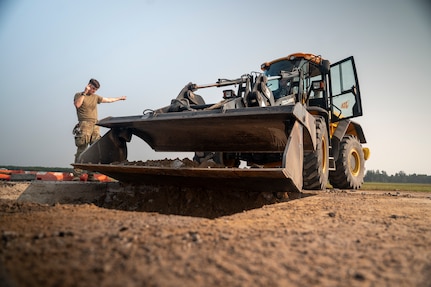 United States Air Force service members perform repairs to an airfield taxiway