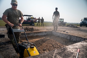 United States Air Force service members perform repairs to an airfield taxiway