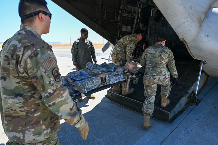 four airmen load medical supplies in an aircraft