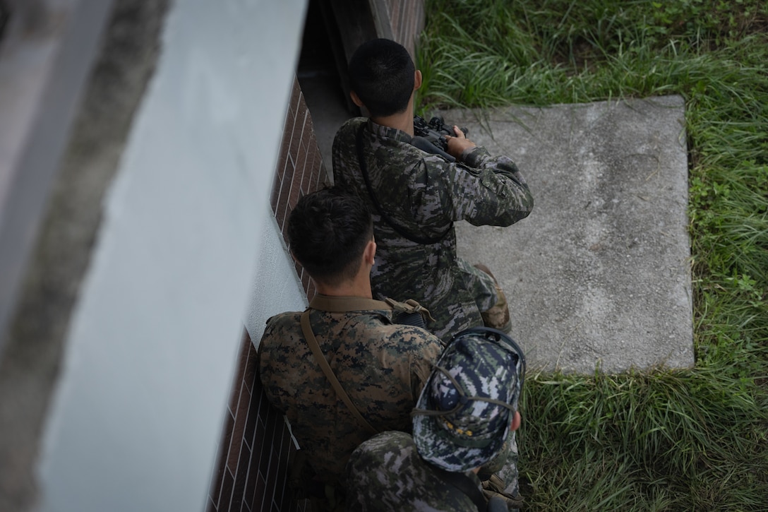 A U.S. Marine with 2nd Battalion, 23rd Marines, forward deployed with 4th Marine Regiment, 3d Marine Division as part of the Unit Deployment Program, and Republic of Korea Marines form a stack prior to assaulting into a building during bilateral military operations in urban terrain training during the Korean Marine Exercise Program 25.2 in Pocheon, South Korea, July 24, 2025. KMEP is conducted regularly between the ROK and U.S. Marine Corps to increase their combined capabilities through realistic training geared towards deterrence and maintaining peace in the Indo-Pacific. (U.S. Marine Corps photo by Lance Cpl. Van Hoang)
